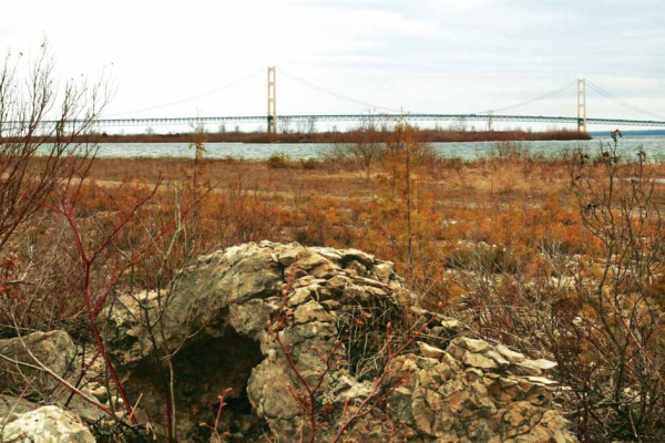 Large boulder of Mackinac breccia on the Lake Michigan shore with Mackinac Bridge in the background